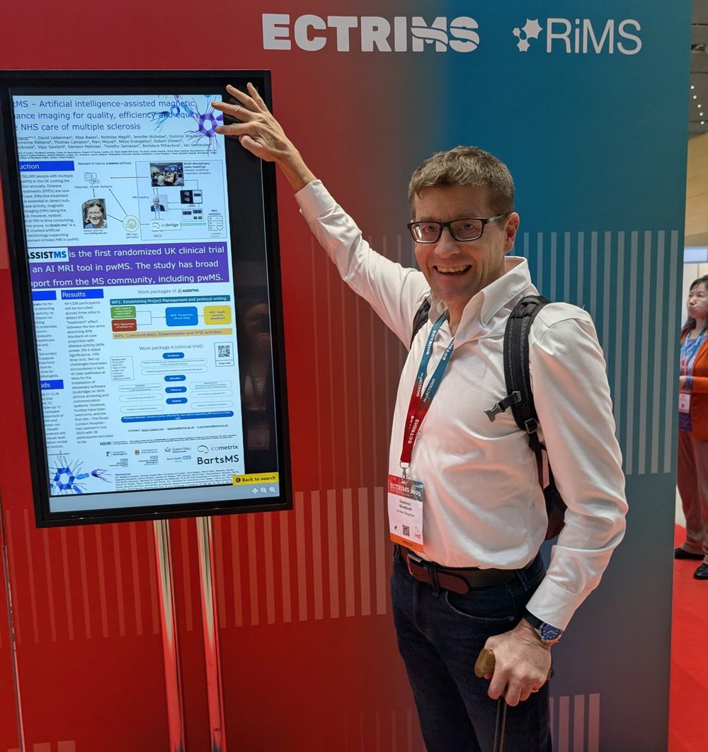Dominic beside a screen showing the AssistMS research poster at ECTRIMS 2025